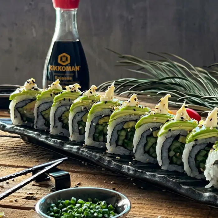 Avokadotoppade maki-rolls med sesamfrön på svart fat hos Khaan Sushi i Falköping